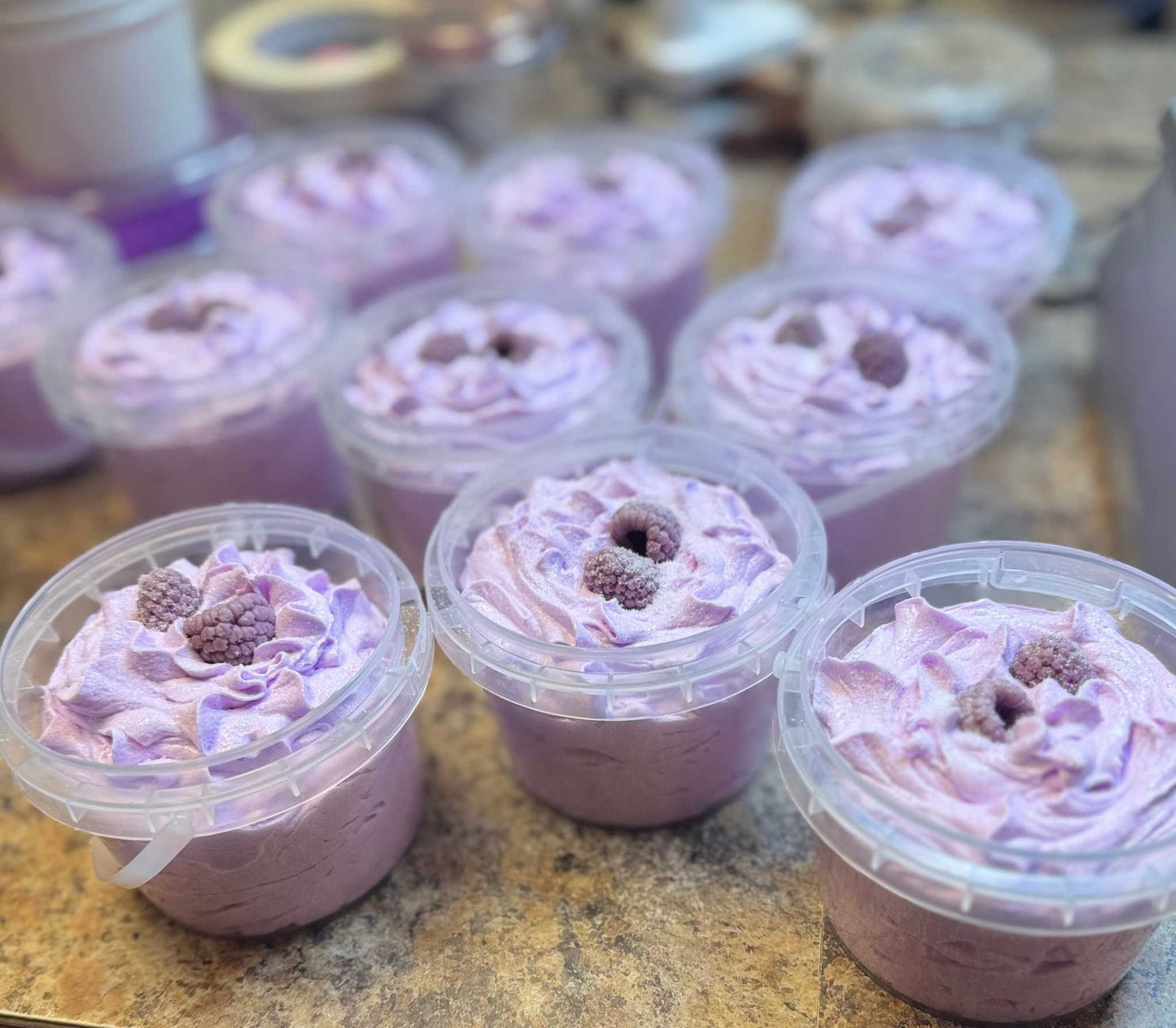 Foaming sugar scrub Berry Bliss whipped soap with purple whipped texture and berry topping in clear containers