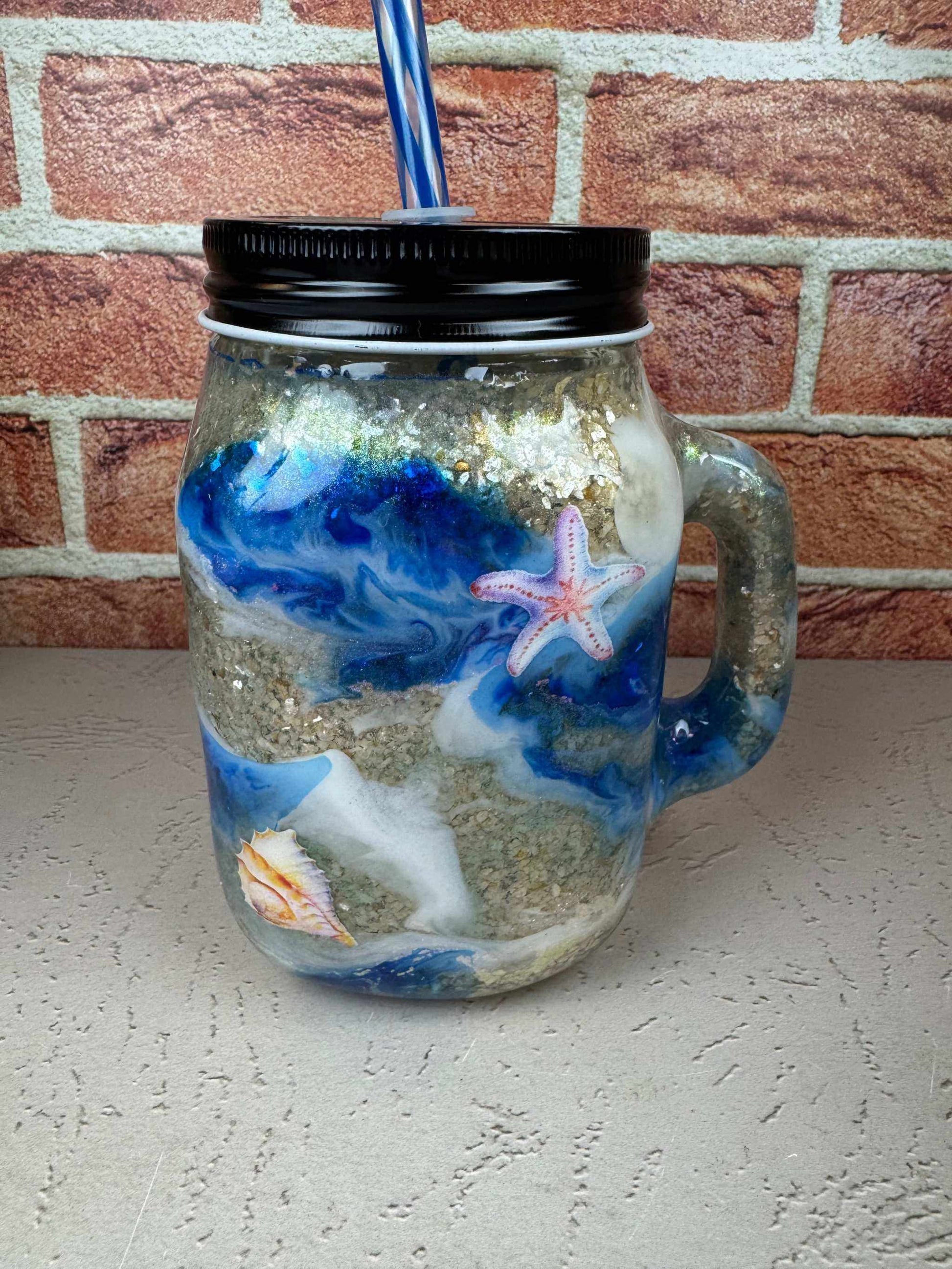 Seashell mason jar mug with beach-themed ocean design and straw for coastal drinkware enthusiasts
