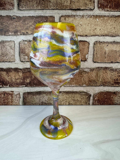 Handcrafted yellow wine glass with purple and white swirls, artisanal design