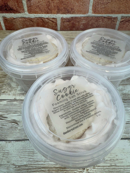 Foaming Salt Scrub Sugar Cookie whipped soap exfoliating sea salt skincare product in clear round containers on wooden surface