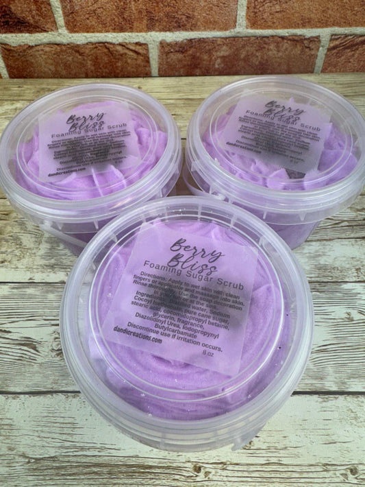 Foaming Sugar Scrub Berry Bliss whipped soap in clear containers with purple lather on wooden surface