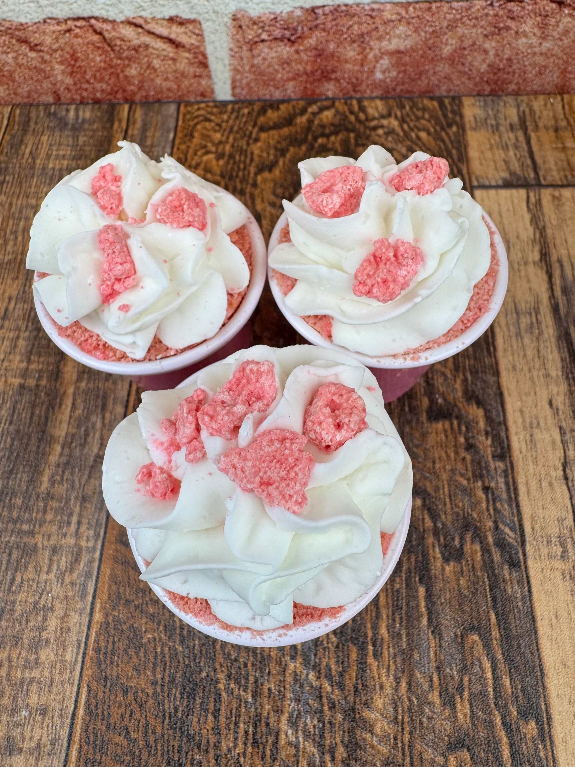 Pink Berry Bubble Shots foaming sugar scrub bath bombs with bubble frosting on wooden surface