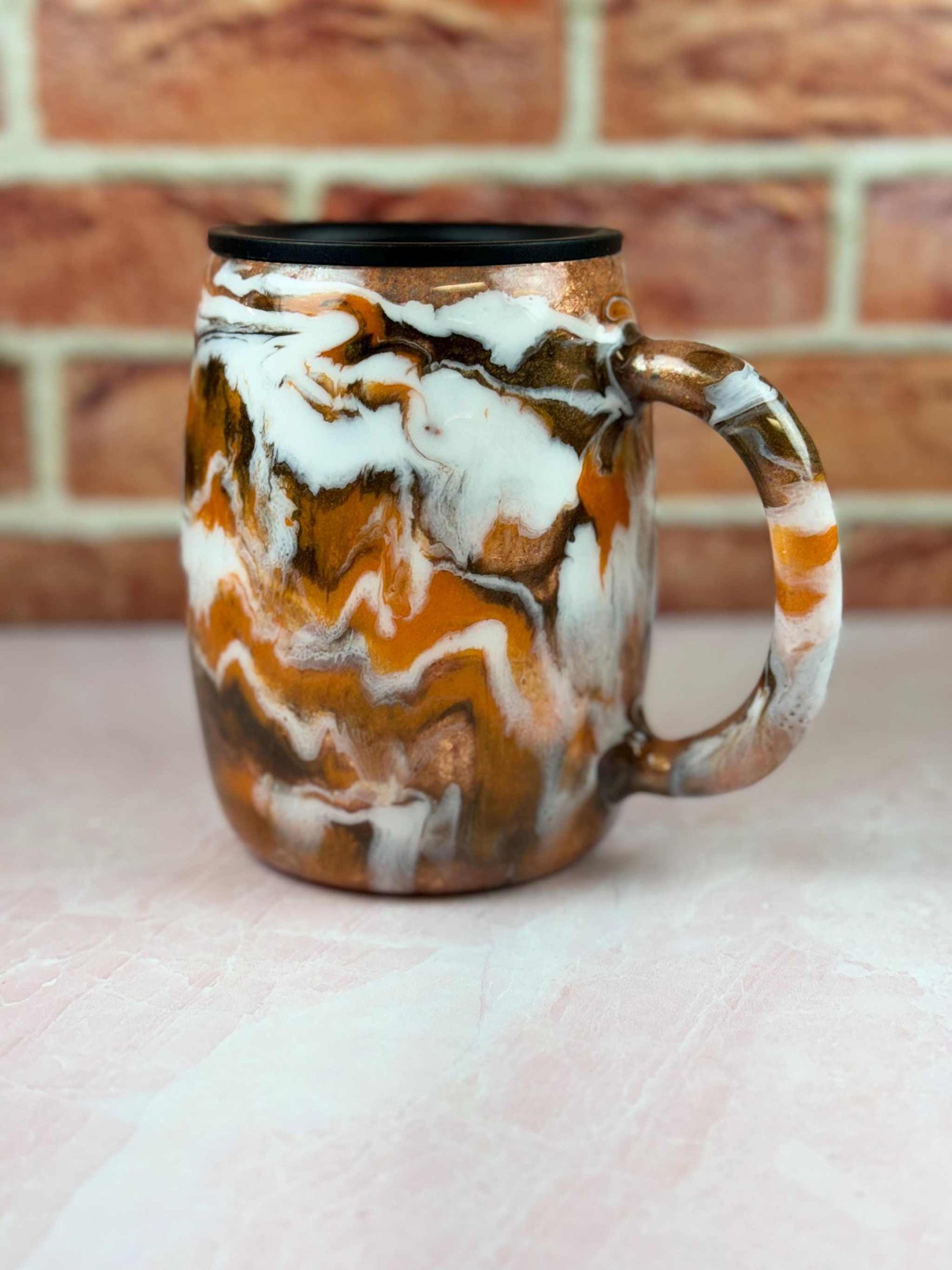 Autumn Tumbler with marbled orange, brown, and white design and black lid for insulated coffee on the go