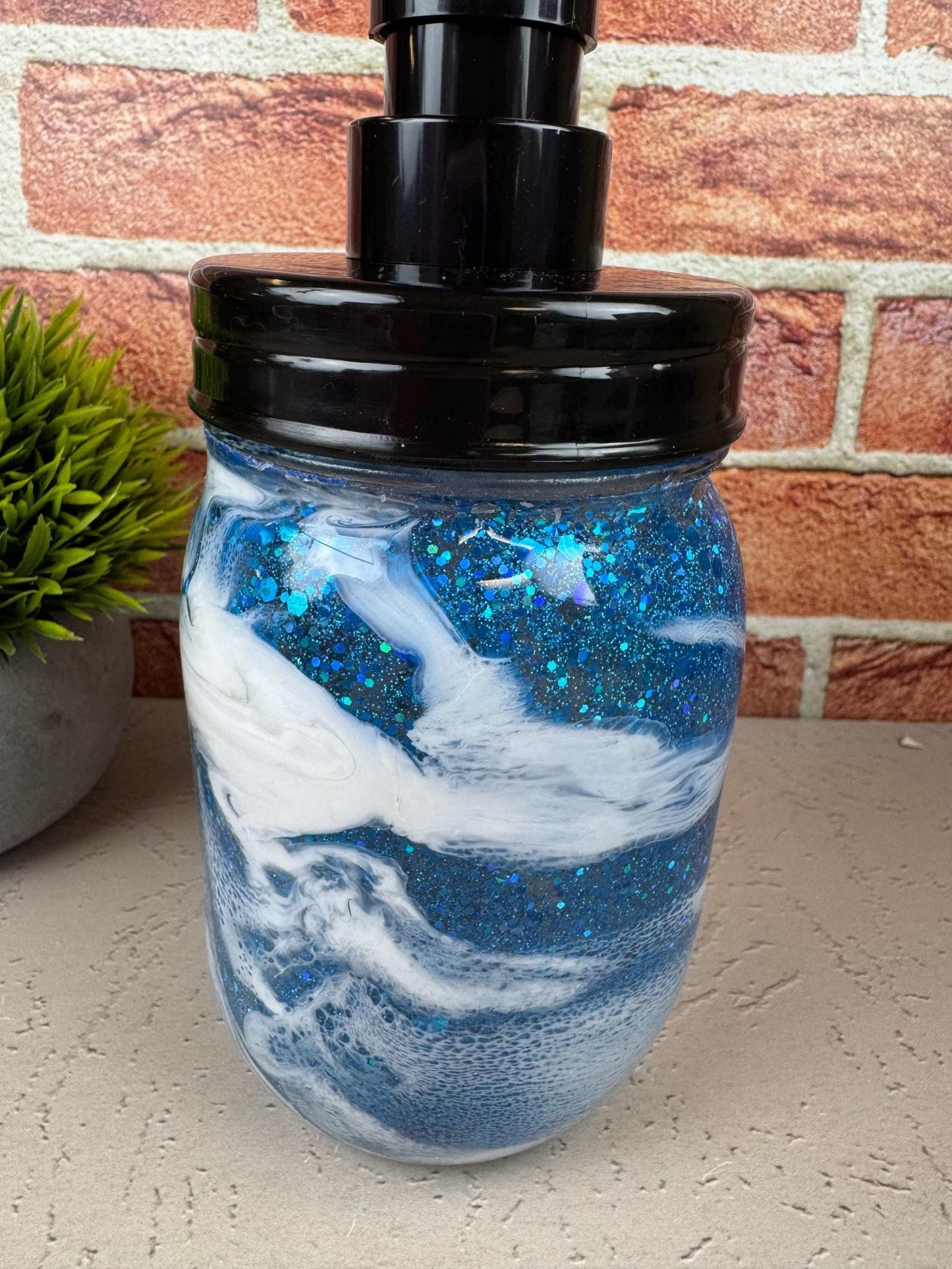 Blue soap dispenser with black pump and sparkly coastal design