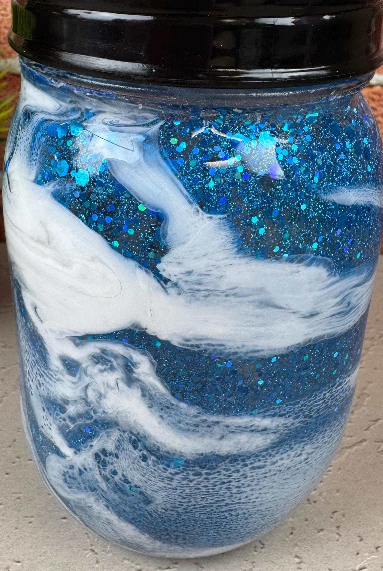 Blue soap dispenser with black pump for coastal bathroom decor