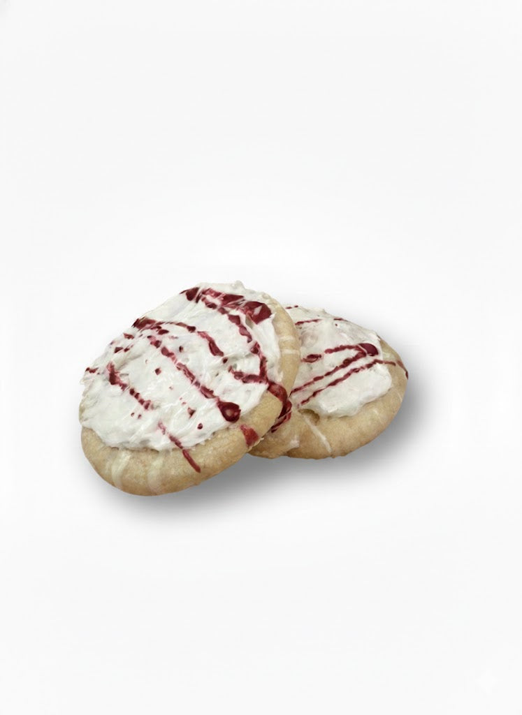 Two bubble cookies with white icing and red drizzle on a white background