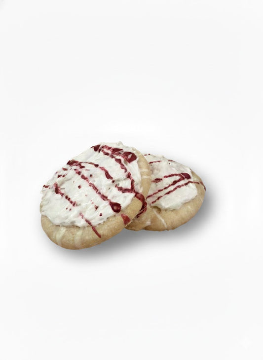 Two bubble cookies with white icing and red drizzle on a white background