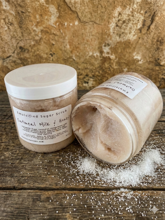 Two jars of emulsified sugar scrub on a wooden surface with a stone background